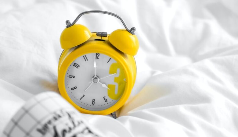 yellow and white analog alarm clock at 10 10